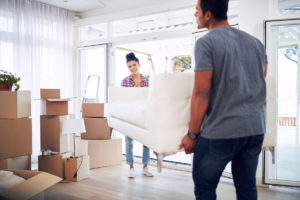 Couple moving sofa using deadlifts and deadshifts